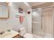 Cozy bathroom featuring a shower with sliding glass doors, toilet, sink and vanity with a warm, neutral color palette at 9925 W Progress Pl, Littleton, CO 80123