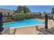 Community pool surrounded by lounge chairs, trees, and nearby residential buildings at 9925 W Progress Pl, Littleton, CO 80123