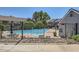 Exterior view of a community pool showcasing lounge areas, mature trees, and a secure fence at 9925 W Progress Pl, Littleton, CO 80123