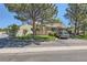 Home exterior with mature trees, manicured lawn, and a paved driveway leading to the house at 9925 W Progress Pl, Littleton, CO 80123