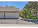 Exterior view of a well-maintained home featuring a two-car garage and manicured lawn at 9925 W Progress Pl, Littleton, CO 80123