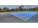 Community tennis court surrounded by mature trees on a sunny day at 9925 W Progress Pl, Littleton, CO 80123