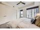 Charming bedroom featuring a ceiling fan, slider closet door, and expansive windows with city views at 1750 Wewatta St # 704, Denver, CO 80202