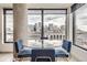 Chic dining area with city views, a sleek glass table, and stylish blue chairs at 1750 Wewatta St # 704, Denver, CO 80202