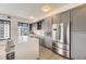 Modern kitchen with stainless steel appliances, a large island, and sleek gray cabinets at 1750 Wewatta St # 704, Denver, CO 80202