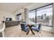 Open living space with a dining table, comfortable sofa, and a view of the cityscape at 1750 Wewatta St # 704, Denver, CO 80202