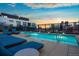 Rooftop pool with lounge chairs and city skyline views at sunset at 1750 Wewatta St # 704, Denver, CO 80202