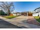 Charming single-story home featuring a spacious front yard, a driveway, and a detached two-car garage at 1014 Ponderosa Cir, Longmont, CO 80504