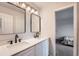 Modern bathroom with double vanity, updated fixtures and a view into a bedroom at 55 N Pines Trl, Parker, CO 80138