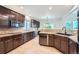 Open kitchen with dark wood cabinetry, granite countertops, and tile backsplash at 55 N Pines Trl, Parker, CO 80138