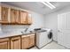 Laundry room with wood cabinets, sink, washer and dryer at 55 N Pines Trl, Parker, CO 80138