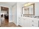 Bathroom with a white vanity and tile backsplash, with an open doorway into an adjacent room at 10151 E 138Th Pl, Brighton, CO 80602