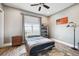 Cozy bedroom featuring neutral walls, a ceiling fan, a window with views, and a decorative American flag at 10151 E 138Th Pl, Brighton, CO 80602