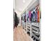 A well organized walk-in closet has hanging rods, shelves, baskets, and plenty of storage space for clothing and shoes at 10151 E 138Th Pl, Brighton, CO 80602