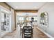 A sun-filled dining room has wood floors, a wooden table with seating for 10, and opens to other living spaces at 10151 E 138Th Pl, Brighton, CO 80602