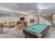 A staged basement with a pool table, seating, and TV offers a cozy entertainment area at 3000 Alkire St, Golden, CO 80401