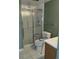 Functional bathroom with tiled floor, glass-enclosed shower, and toilet with safety rails at 680 S Alton Way # 9A, Denver, CO 80247