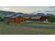 Aerial view of the architectural home with mature landscaping, metal roof, and long driveway at 6455 Dakota Ridge Dr, Golden, CO 80403