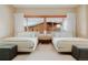 Bright bedroom with two beds, light carpet, neutral walls and a large window with natural wood trim at 6455 Dakota Ridge Dr, Golden, CO 80403