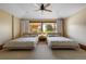 Bedroom with two beds, light carpet, neutral walls and a large window that brings in lots of light at 6455 Dakota Ridge Dr, Golden, CO 80403