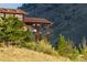 Exterior view of the house with wood beam supports and lush mountain views at 6455 Dakota Ridge Dr, Golden, CO 80403