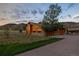 Exterior view of the home featuring a wooden exterior, stone accents, mature trees, and a driveway at 6455 Dakota Ridge Dr, Golden, CO 80403