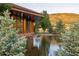 Exterior view of property featuring large pond, wood accents and natural landscaping at 6455 Dakota Ridge Dr, Golden, CO 80403