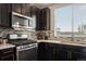 Close up of modern kitchen with stainless steel range, quartz counters and dark cabinetry at 2521 Moline St, Aurora, CO 80010