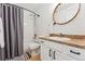 This bathroom features a shower-tub combo and a round wood-framed mirror at 4774 Coker Ave, Castle Rock, CO 80104