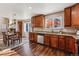 Stylish eat-in kitchen featuring warm wood cabinetry, granite counters, stainless appliances, and wood floors at 4774 Coker Ave, Castle Rock, CO 80104