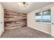 Bedroom featuring neutral carpet and a rustic wood accent wall and bright window overlooking the backyard at 1010 Ash St, Broomfield, CO 80020