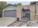 The front exterior shows off the brick arch, flowerbeds, and a two car garage at 1010 Ash St, Broomfield, CO 80020