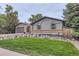The home's exterior features a manicured lawn, rock garden, and easy access two-car garage at 1010 Ash St, Broomfield, CO 80020