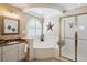 A bright bathroom featuring a soaking tub, a glass shower, and a granite vanity with modern fixtures at 6502 Shea Pl, Highlands Ranch, CO 80130