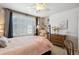 Sunlit bedroom showcasing a four-poster bed, plantation shutters, and soft decor at 6502 Shea Pl, Highlands Ranch, CO 80130
