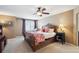 This bedroom boasts a large bed with an ornate headboard, neutral walls, and a ceiling fan at 6502 Shea Pl, Highlands Ranch, CO 80130