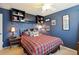 Inviting bedroom with built-in shelving, TV, and a comfortable queen-size bed with a red and black plaid comforter at 6502 Shea Pl, Highlands Ranch, CO 80130