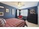 Stylish blue bedroom with a comfortable plaid bed, a chest of drawers, and window views at 6502 Shea Pl, Highlands Ranch, CO 80130