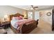 A bedroom shows a large bed with red accents, a ceiling fan, and a view into the en suite bath at 6502 Shea Pl, Highlands Ranch, CO 80130