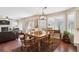 Bright dining area with a wooden table, plantation shutters, and a seamless transition to the living room at 6502 Shea Pl, Highlands Ranch, CO 80130