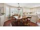 Sunlit dining area features large windows, a stylish light fixture, and a seamless connection to the kitchen at 6502 Shea Pl, Highlands Ranch, CO 80130