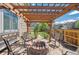 Relaxing outdoor patio with pergola, stone pavers, fire pit, and comfortable seating at 6502 Shea Pl, Highlands Ranch, CO 80130