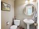Charming powder room with a pedestal sink, decorative mirror, and tasteful decor at 6502 Shea Pl, Highlands Ranch, CO 80130