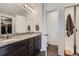 Bright bathroom with double vanity with granite countertop, dark cabinets, and walk-in shower at 42830 Ivydel St, Elizabeth, CO 80107