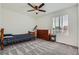 Bright bedroom features neutral walls, gray carpet, a ceiling fan, and a large window with natural light at 42830 Ivydel St, Elizabeth, CO 80107