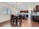 Bright dining area features wood floors, view-filled window, and chandelier lighting adjacent to the open kitchen at 42830 Ivydel St, Elizabeth, CO 80107