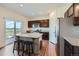Kitchen with dark wood cabinets, granite counters, stainless appliances, island with breakfast bar seating at 42830 Ivydel St, Elizabeth, CO 80107