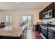 Kitchen features a granite countertop, stainless steel appliances, island and access to outdoor living at 42830 Ivydel St, Elizabeth, CO 80107