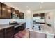 Kitchen features stainless steel appliances, granite counters, dark wood cabinets, and an island with sink at 42830 Ivydel St, Elizabeth, CO 80107