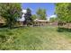 Spacious backyard featuring overgrown grass and a view of the home's exterior at 140 S Kendall St, Lakewood, CO 80226